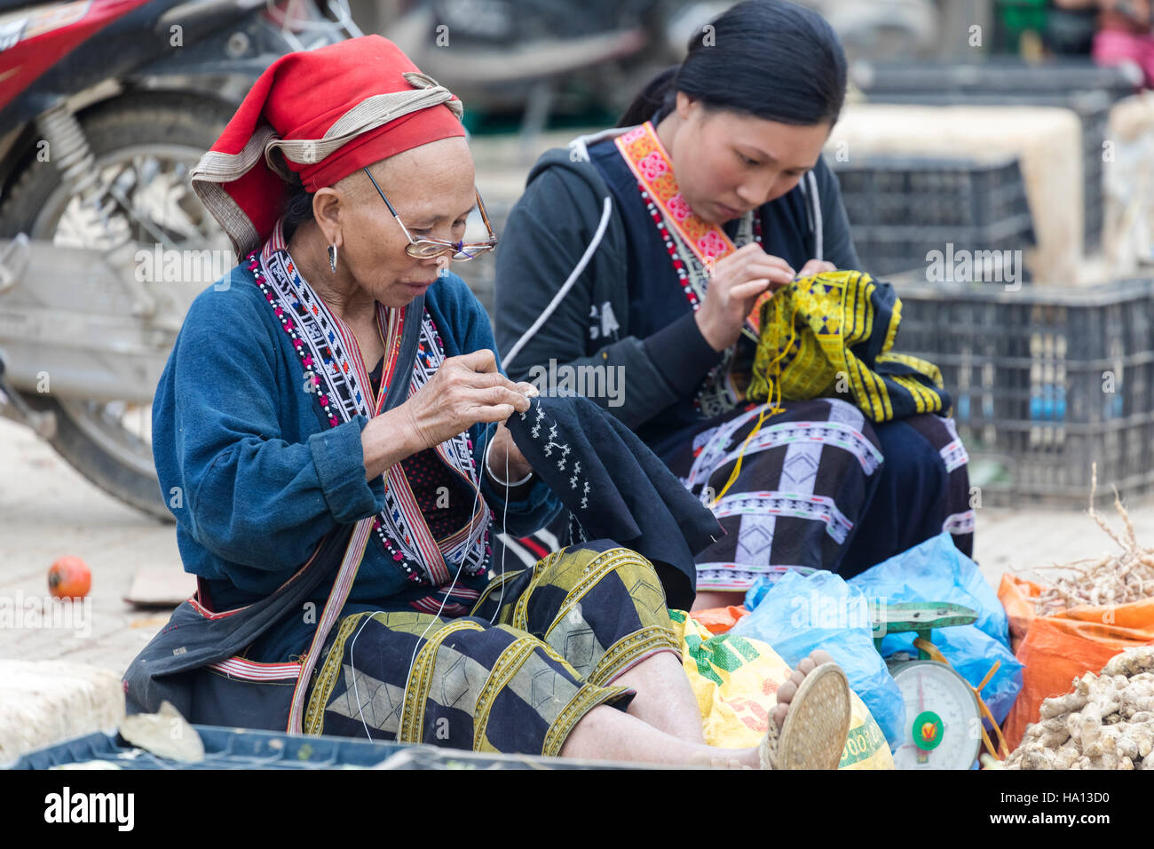 ethnic Red Dzao woman sewing at the local market in Sapa, Vietnam, Asia Stock Photo