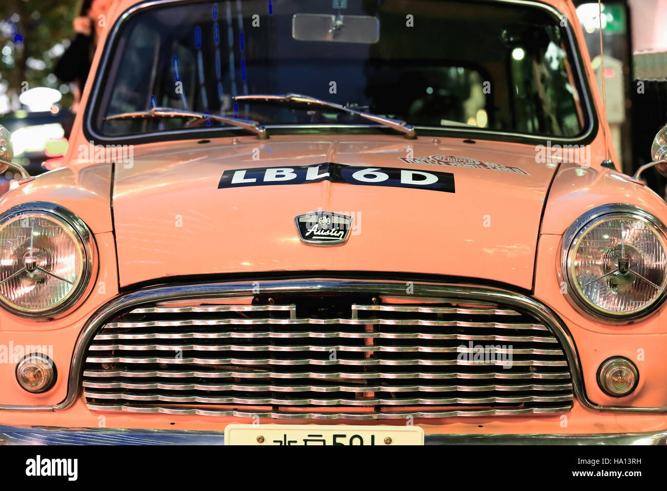Tokyo, Japan-October 23, 2013: The lack of parking spaces on downtown Tokyo makes small cars as the classical-pink painted Austin Mini appearing Stock Photo