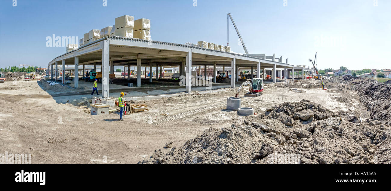 Panorama is showing construction site with machinery, people at work ...