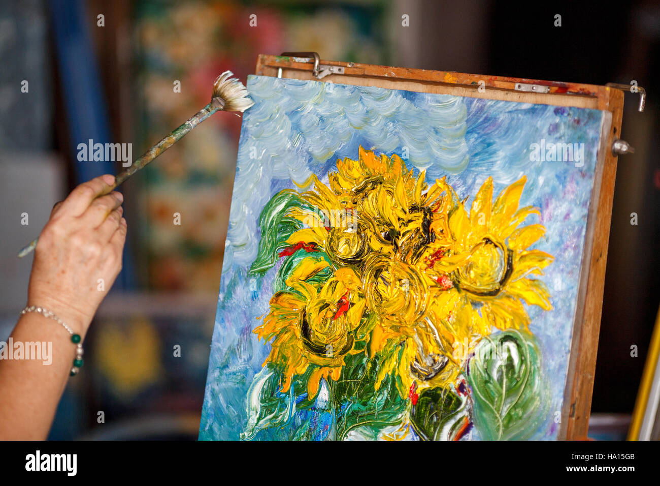 Process of oil painting, artist paints picture on canvas. Sunflowers