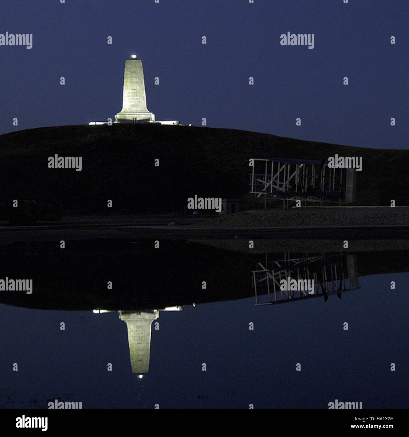 wrightbrosnps 17394162001 From 2002, the Wright Brothers Monument lit up at night and reflected off some water that pooled around the artistic sculpture of the first flight.  # Stock Photo