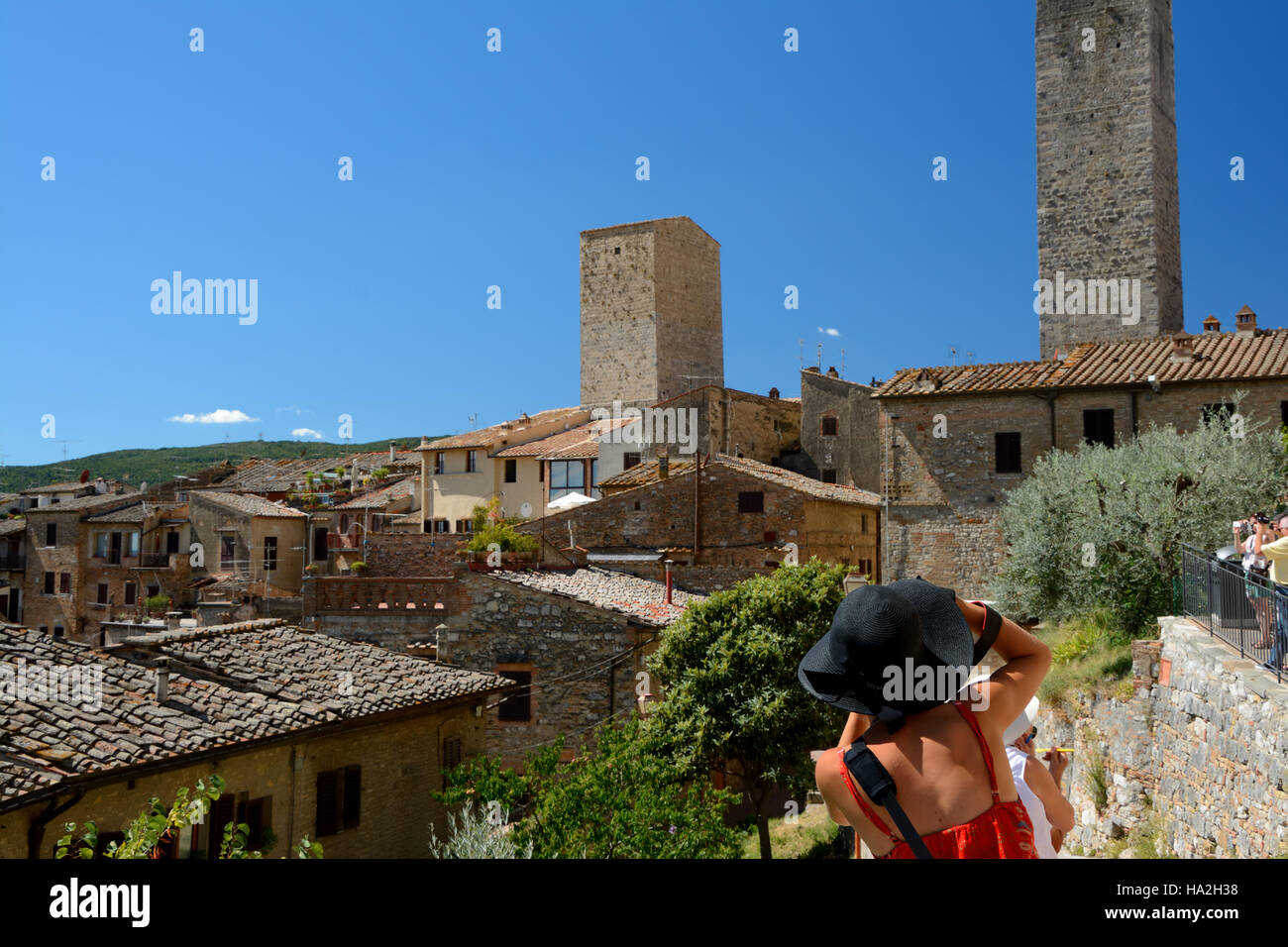 San Gimignano, Italy - September 6, 2016: Unidentified woman in black hat taking picture of San Gimignano city in Tuscany, Italy. Unidentified people Stock Photo