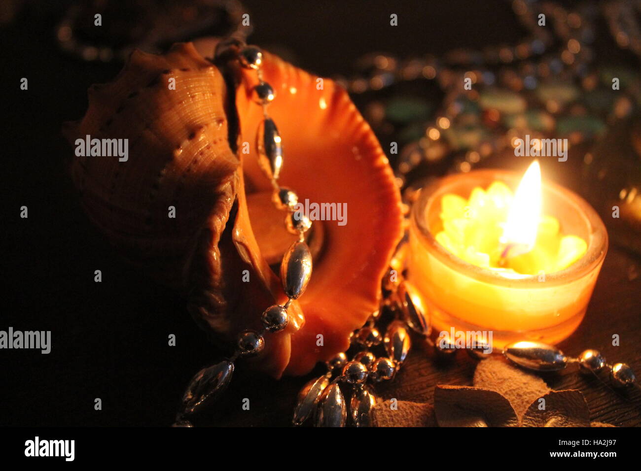 beautiful big shell from sea decorated silver beads and burn candle nice composition for celebration Stock Photo