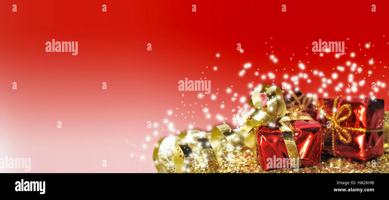 Christmas gifts in golden confetti on red background Stock Photo
