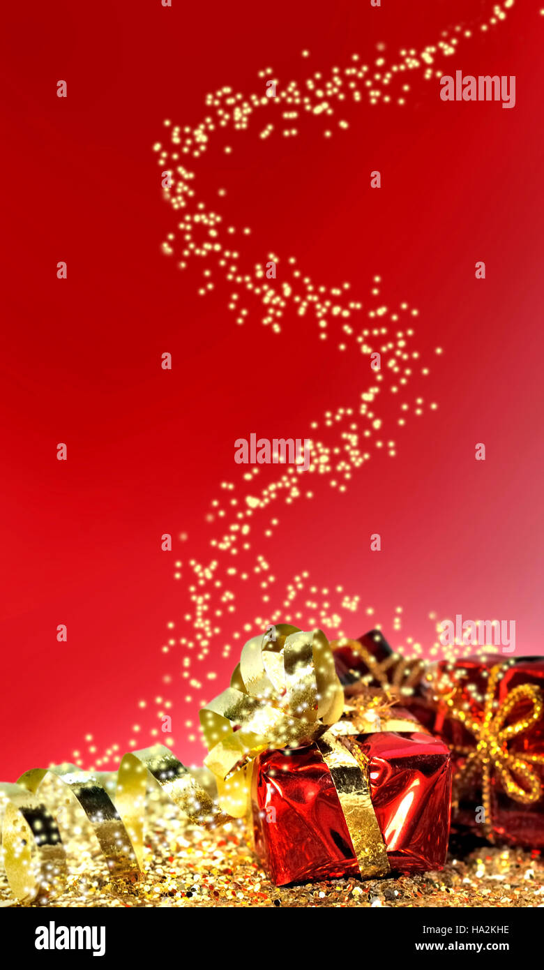 Christmas gifts in golden confetti on red background Stock Photo