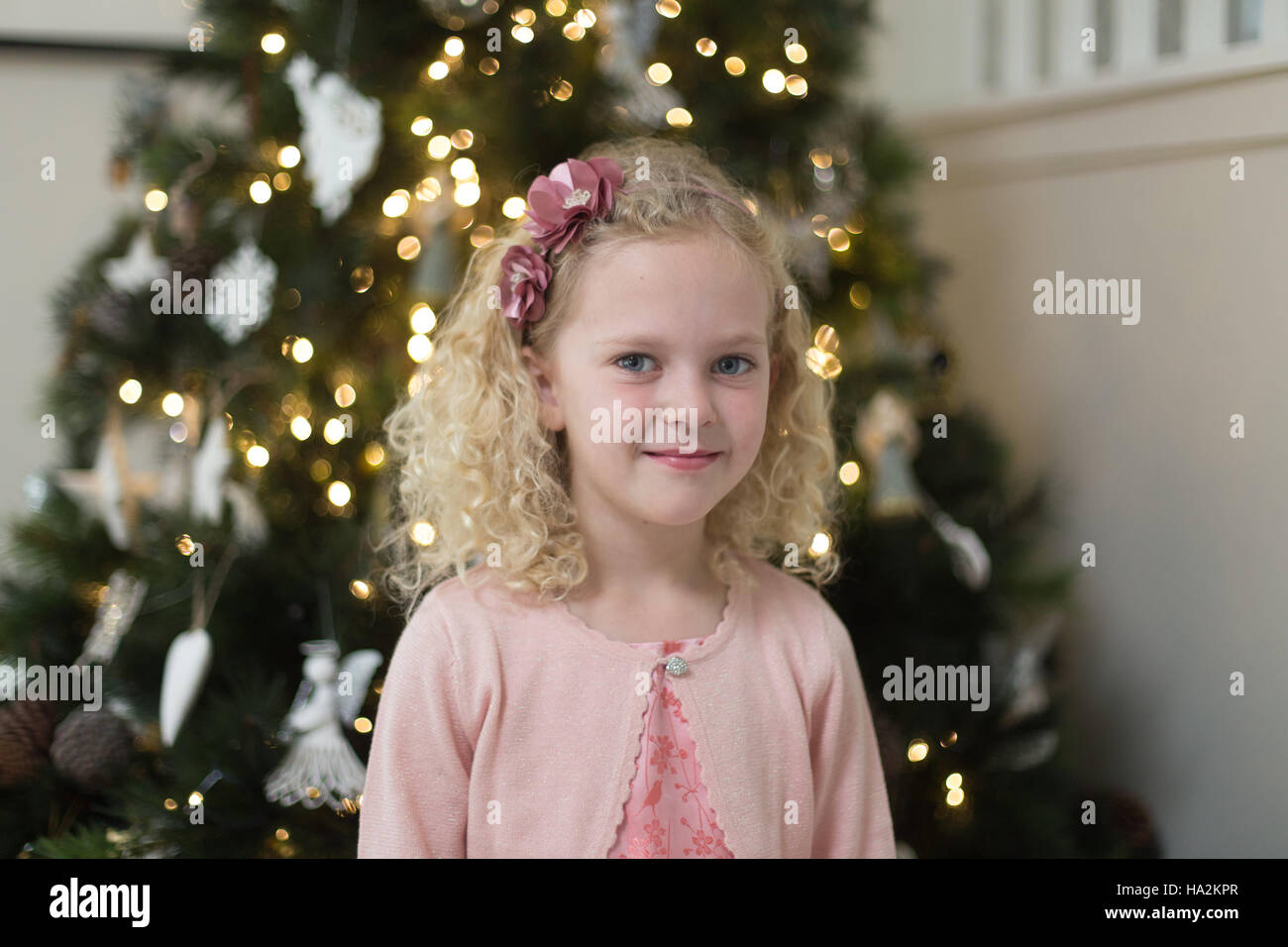 Girl standing in front of a christmas tree Stock Photo - Alamy