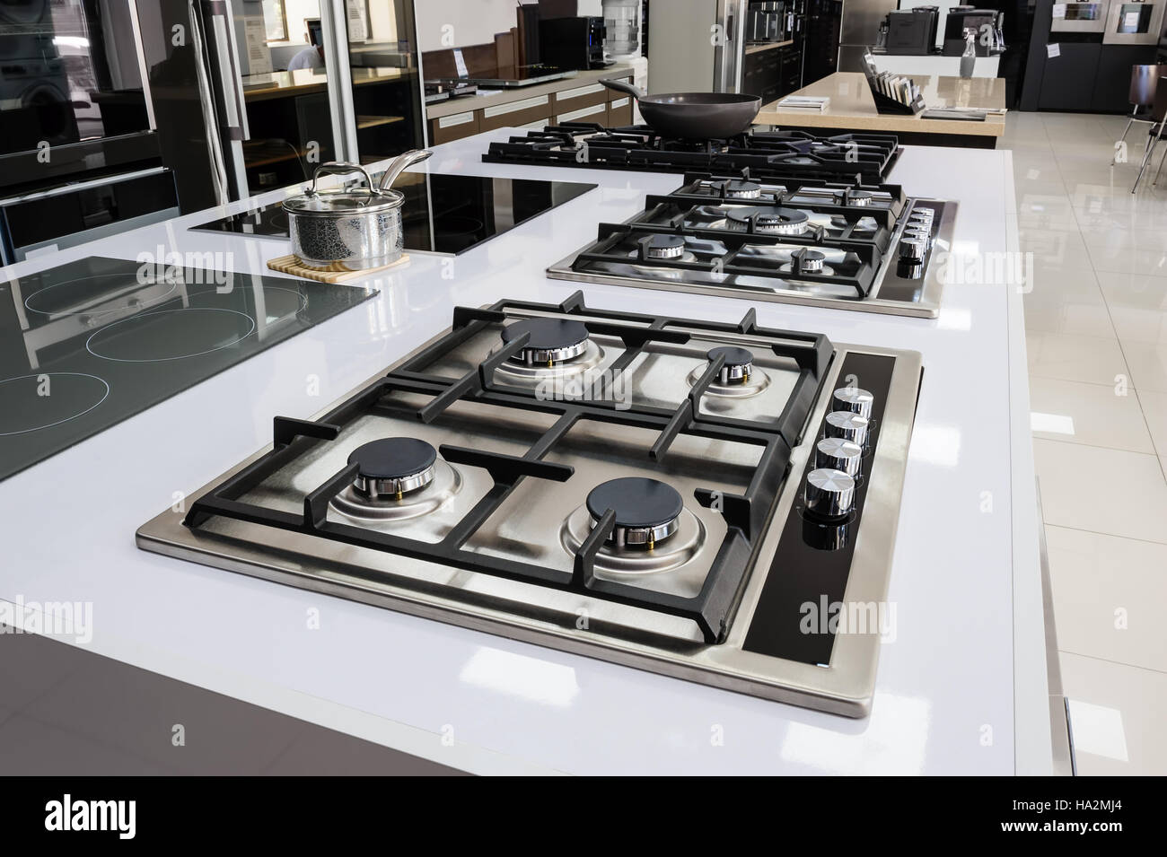 Stainless grey metal kitchen gas stove installed on a the kitchen with a  dark grey table top Stock Photo - Alamy