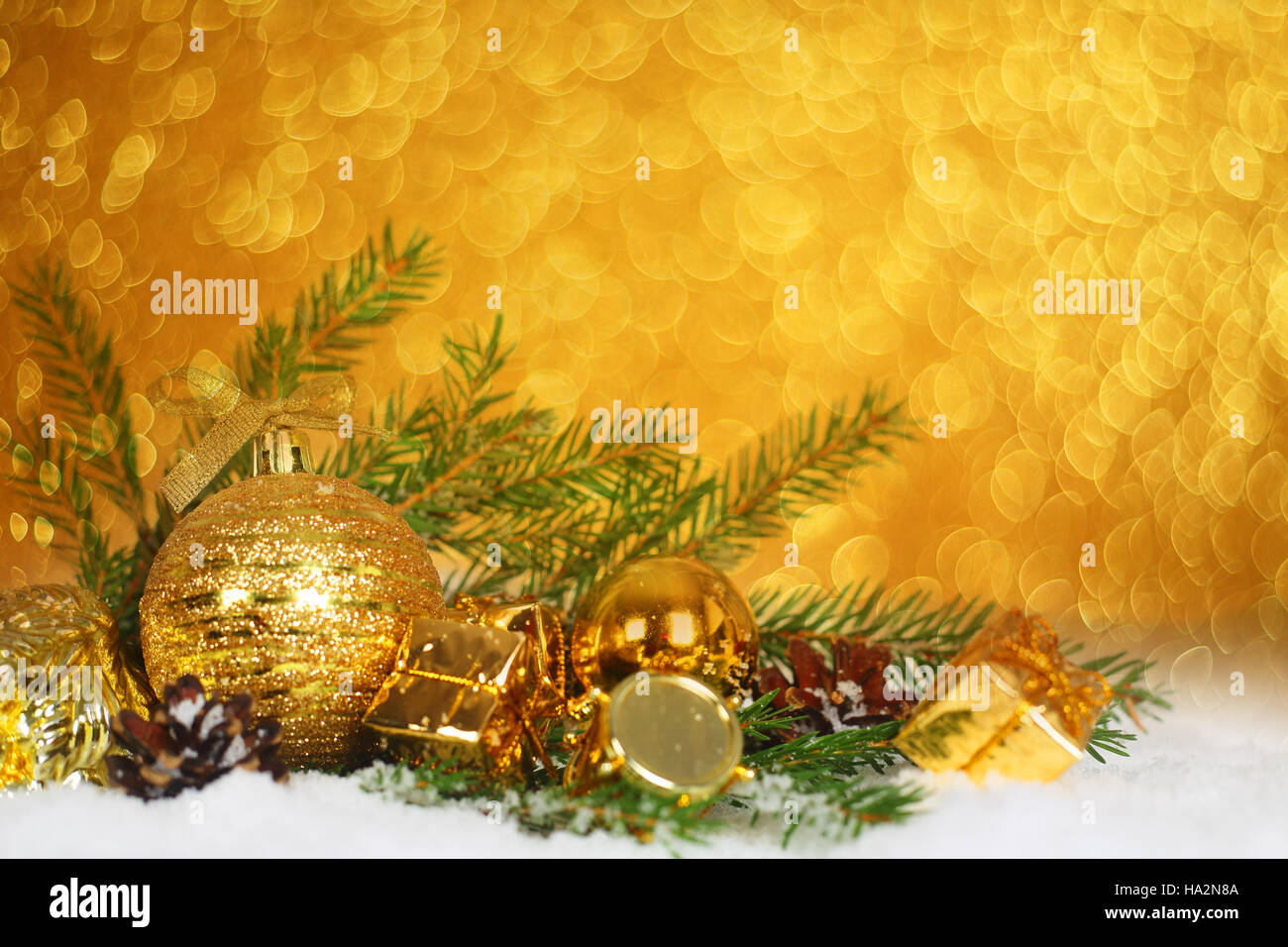 Christmas card with gold baubles and gifts on golden bokeh light ...
