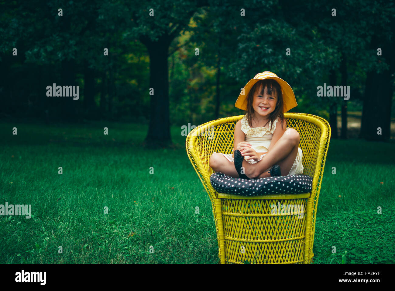 Portrait of a smiling girl sitting in a garden chair Stock Photo
