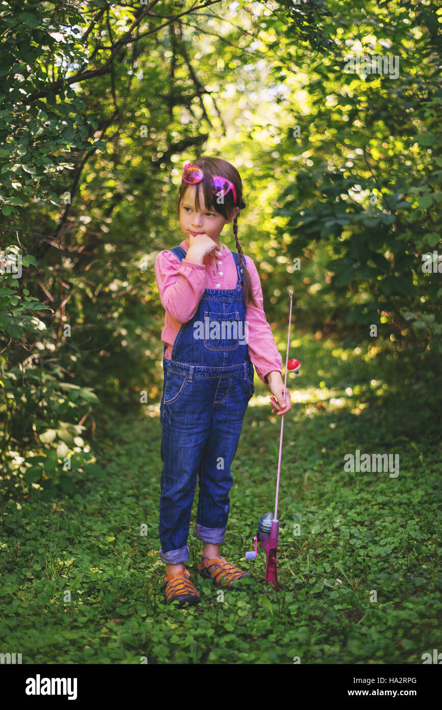 Girl standing in forest with fishing rod Stock Photo Alamy