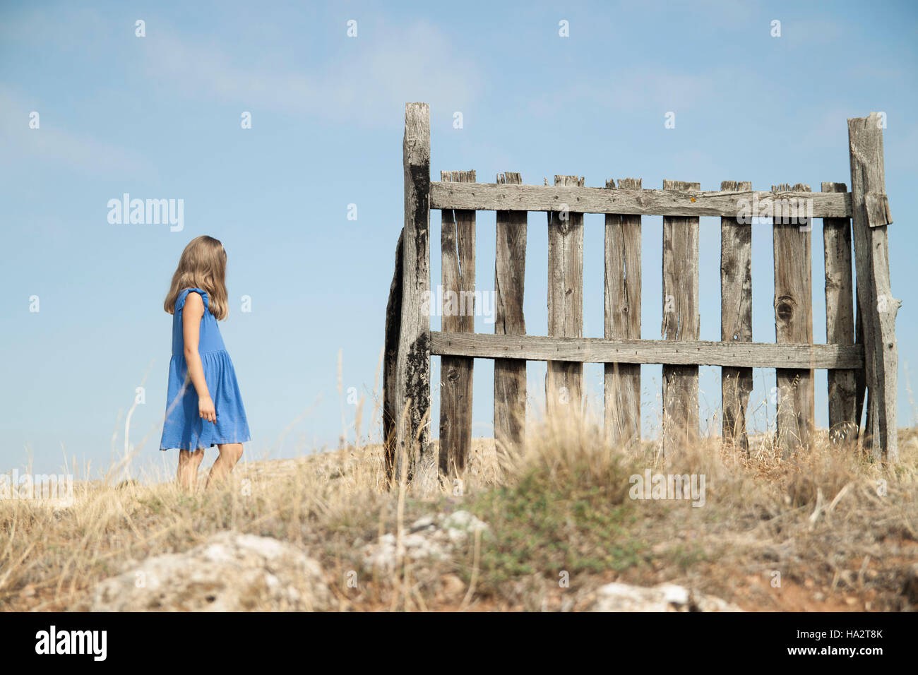 Girl walking past a fence Stock Photo