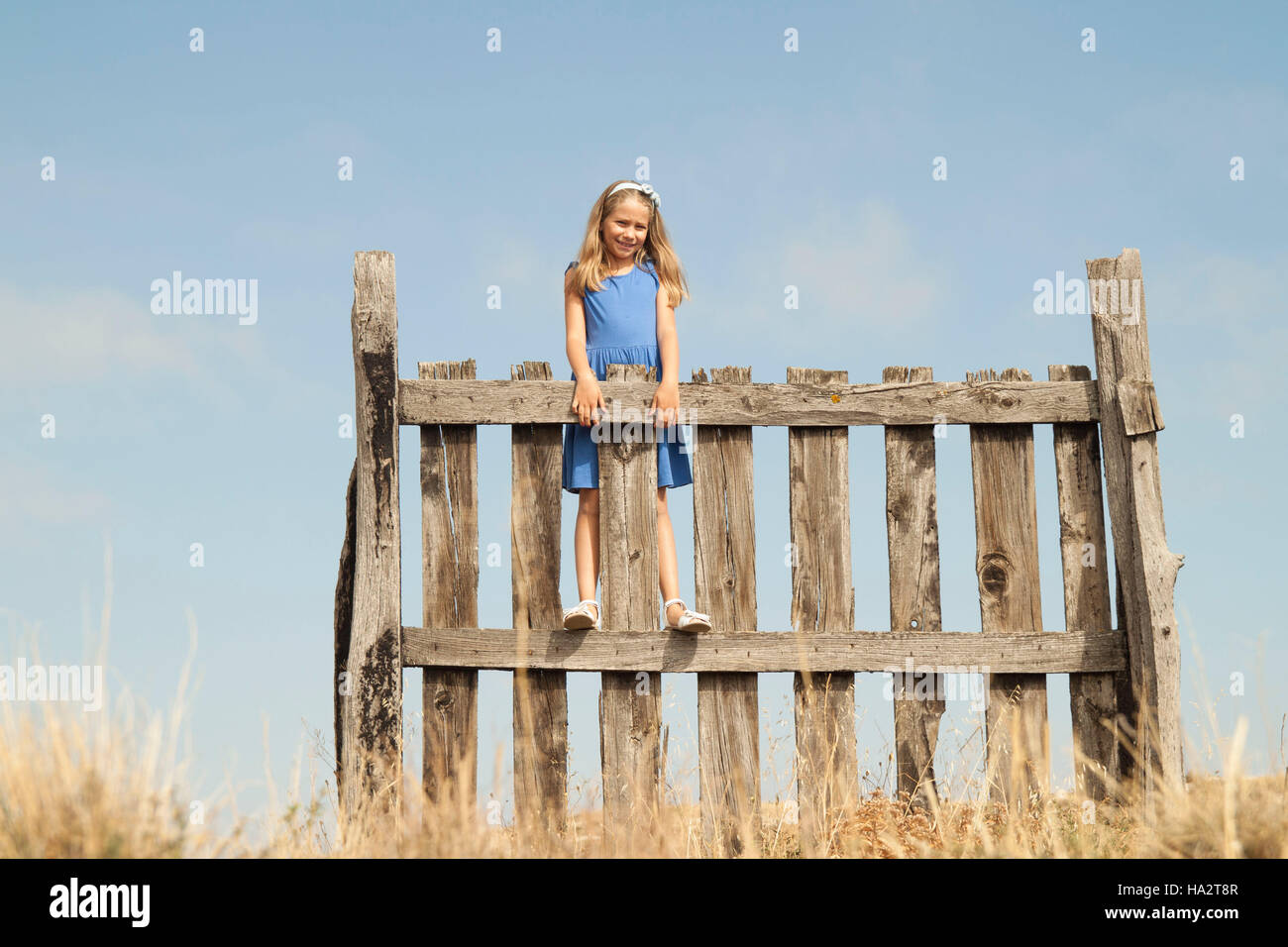 Girl standing on a fence Stock Photo