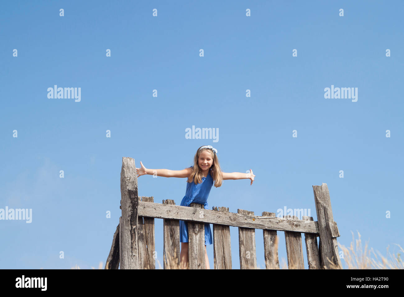 Girl standing on a fence Stock Photo