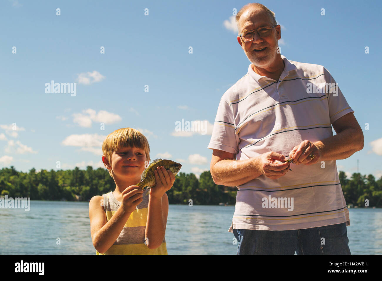 Grandfather and grandson with freshly caught fish Stock Photo