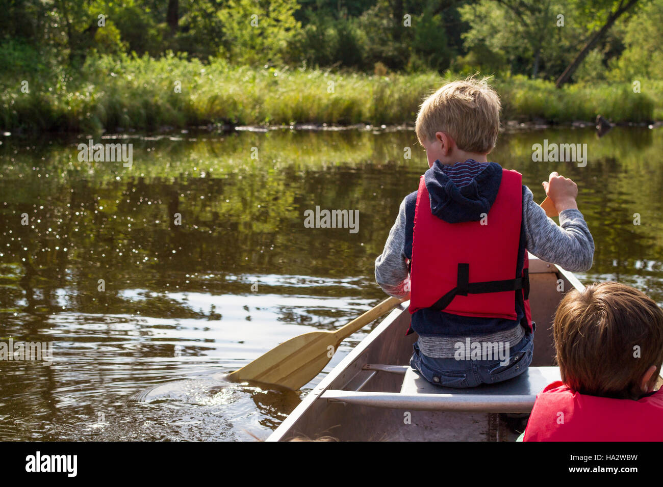 Two boys canoeing on lake Stock Photo