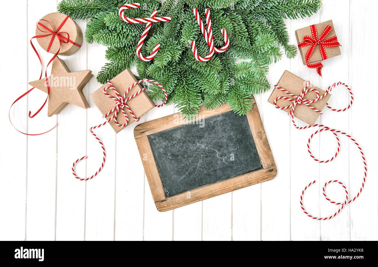 Christmas tree branches with decoration, gift boxes and chalkboard for your text Stock Photo