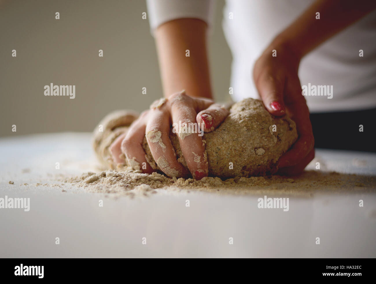 Woman's hands knead dough on a table Stock Photo - Alamy