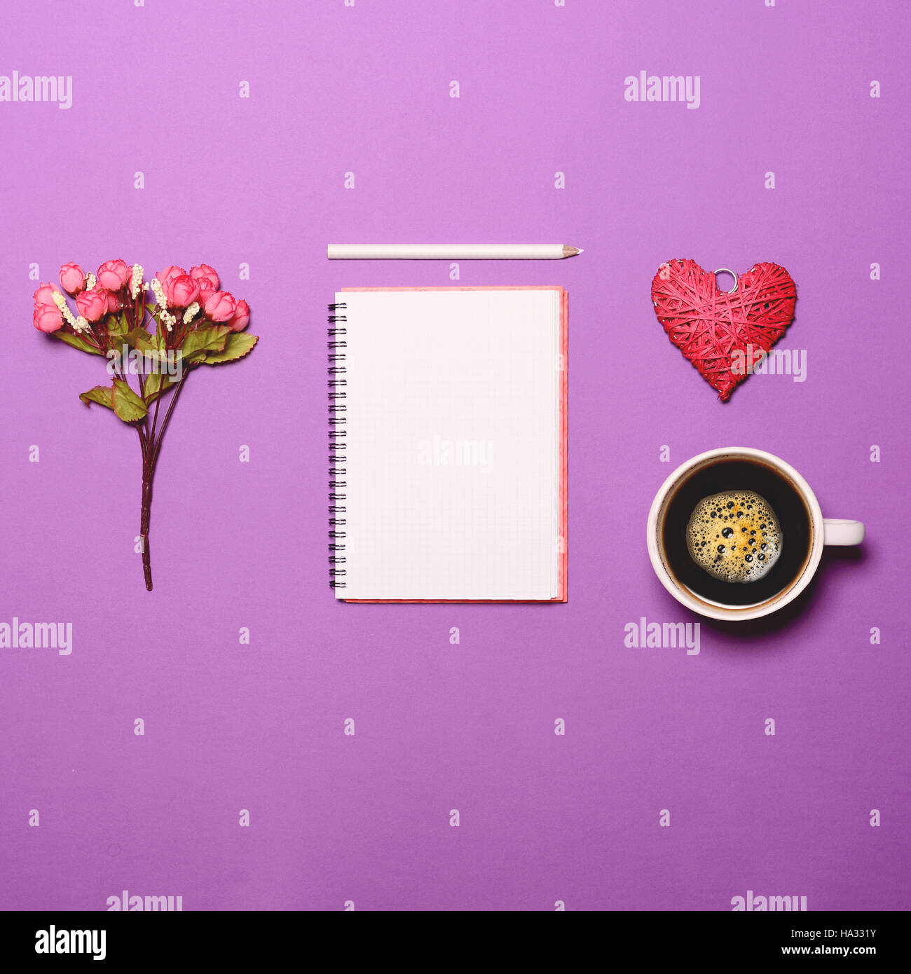 Top view of flower note book with pen heart and cup of coffee on lilac