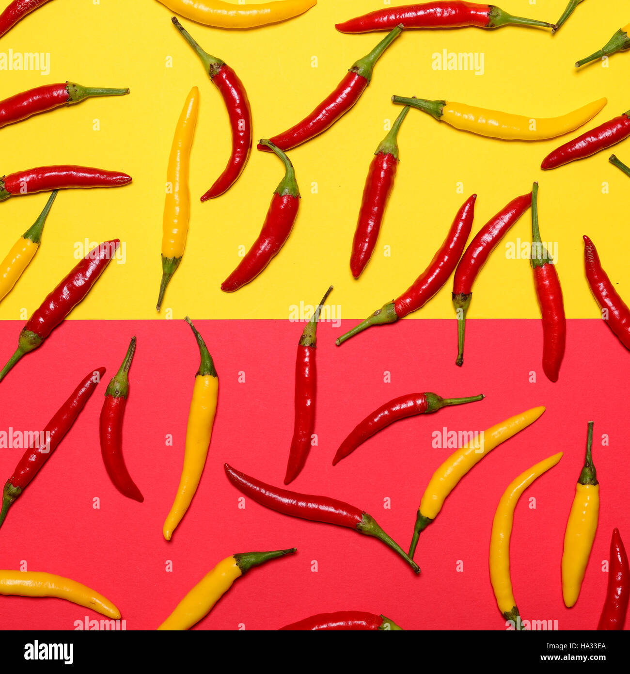 Red and yellow hot chili peppers on red and yellow background Flat