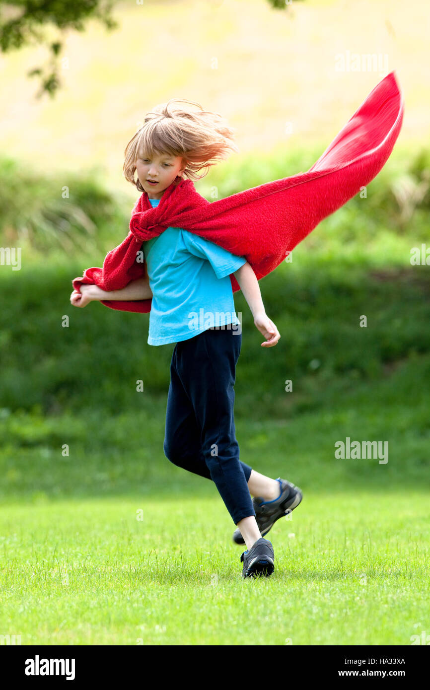 Boy Running Around in Red Towel as Superhero Cloak Stock Photo