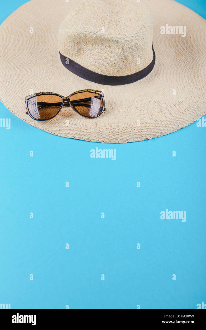 Straw hat and sunglasses on blue background. beach equipment Stock ...