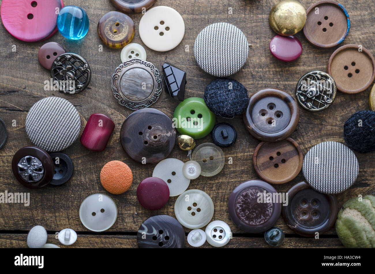 Lot of vintage buttons on old wooden table, from above Stock Photo