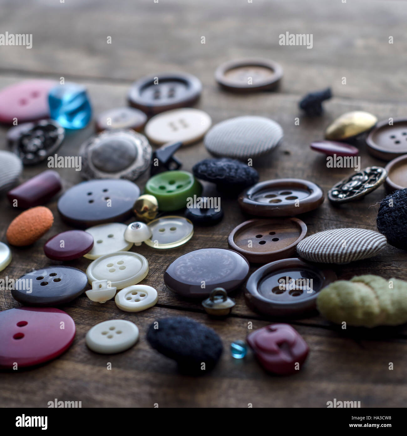 Lot of vintage buttons on old wooden table, close up Stock Photo