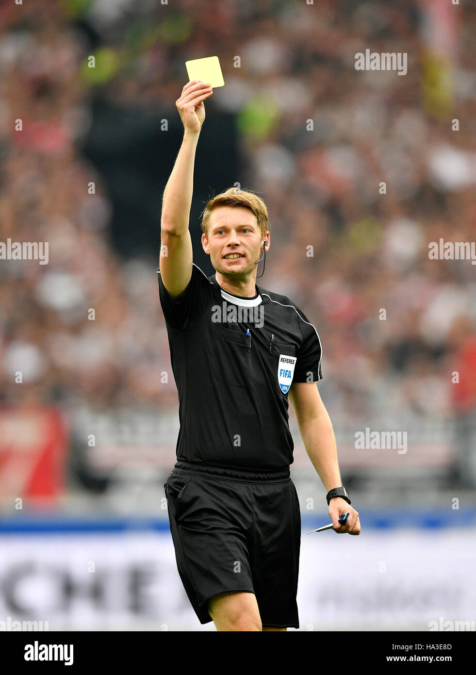 Referee Christian Dingert displays yellow card, warning, Mercedes-Benz Arena, Stuttgart, Baden-Württemberg, Germany Stock Photo