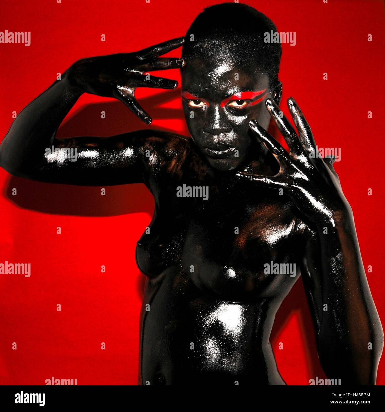 bodypainted girls A black female model bodypainted in black against a red background Stock  Photo - Alamy
