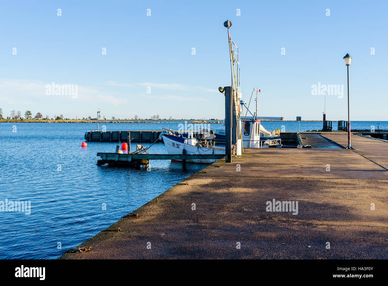 Kristianopel, Sweden - November 24, 2016: Documentary of public access harbor area. Calm day in fall with fishing boat moored dockside. Stock Photo