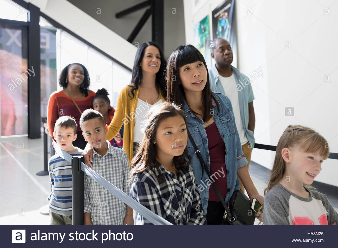 Parents and children waiting in queue at science center Stock Photo Alamy