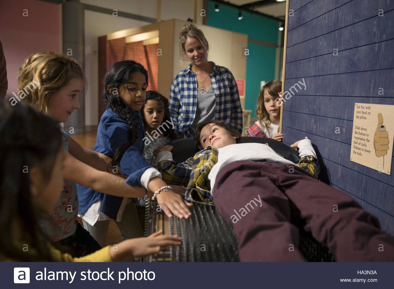 Mother and children at bed of nails exhibit in science center Stock Photo Alamy