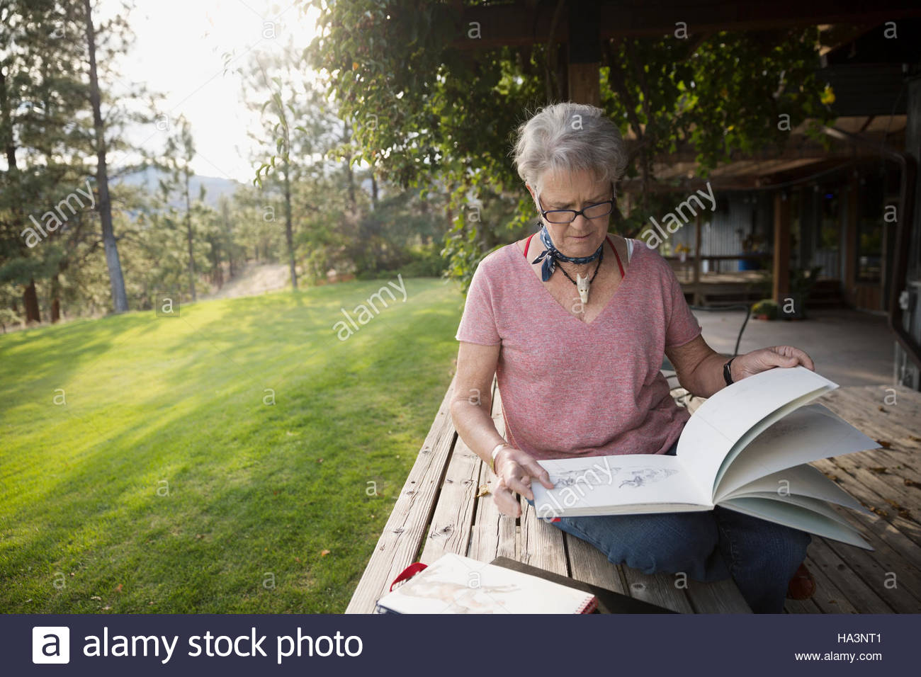 Senior woman artist with sketchbook on patio Stock Photo