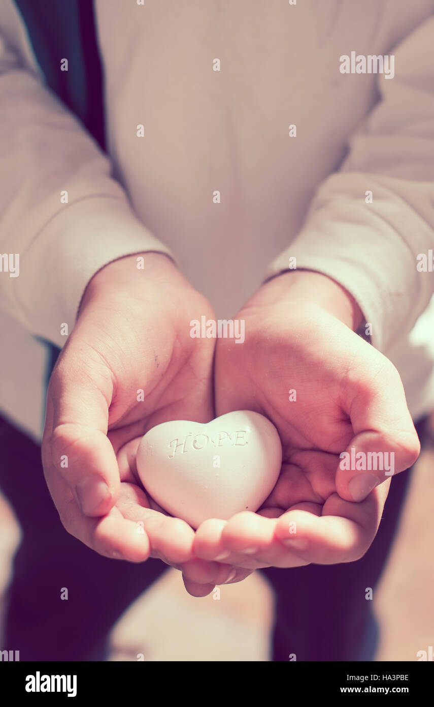 Child hold in hands heart. Text hope. Еxpectation concept Stock Photo