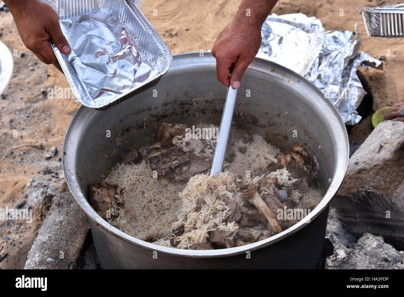 COOKING RICE AND MEAT OVER THE CHARCOAL AND WOOD IN THE PARK, DUBAI,UAE ...