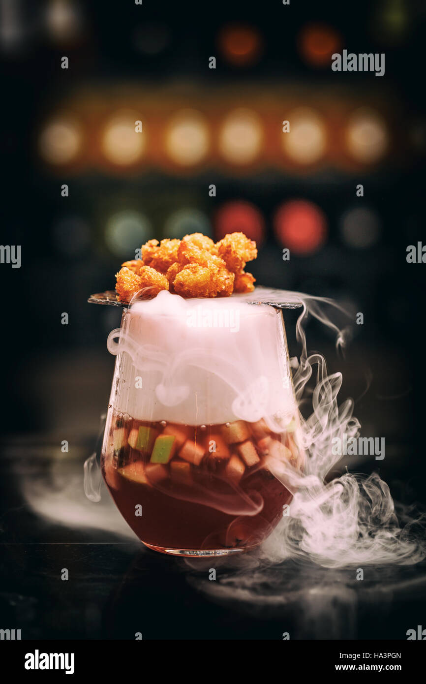 Gourmet smoking fruit soup with shrimp popcorn served on dry ice Stock Photo