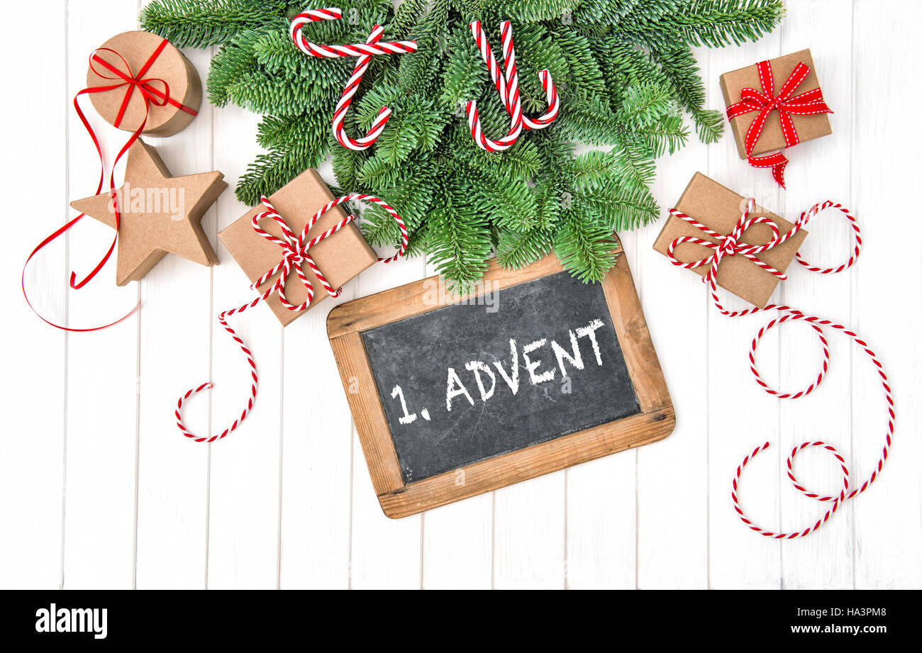 Christmas decoration with chalkboard, gifts and pine tree branches. 1. Advent Stock Photo