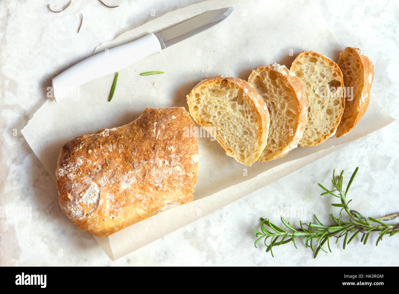 Italian bread Ciabatta and rosemary on white marble background - fresh homemade bread bakery Stock Photo