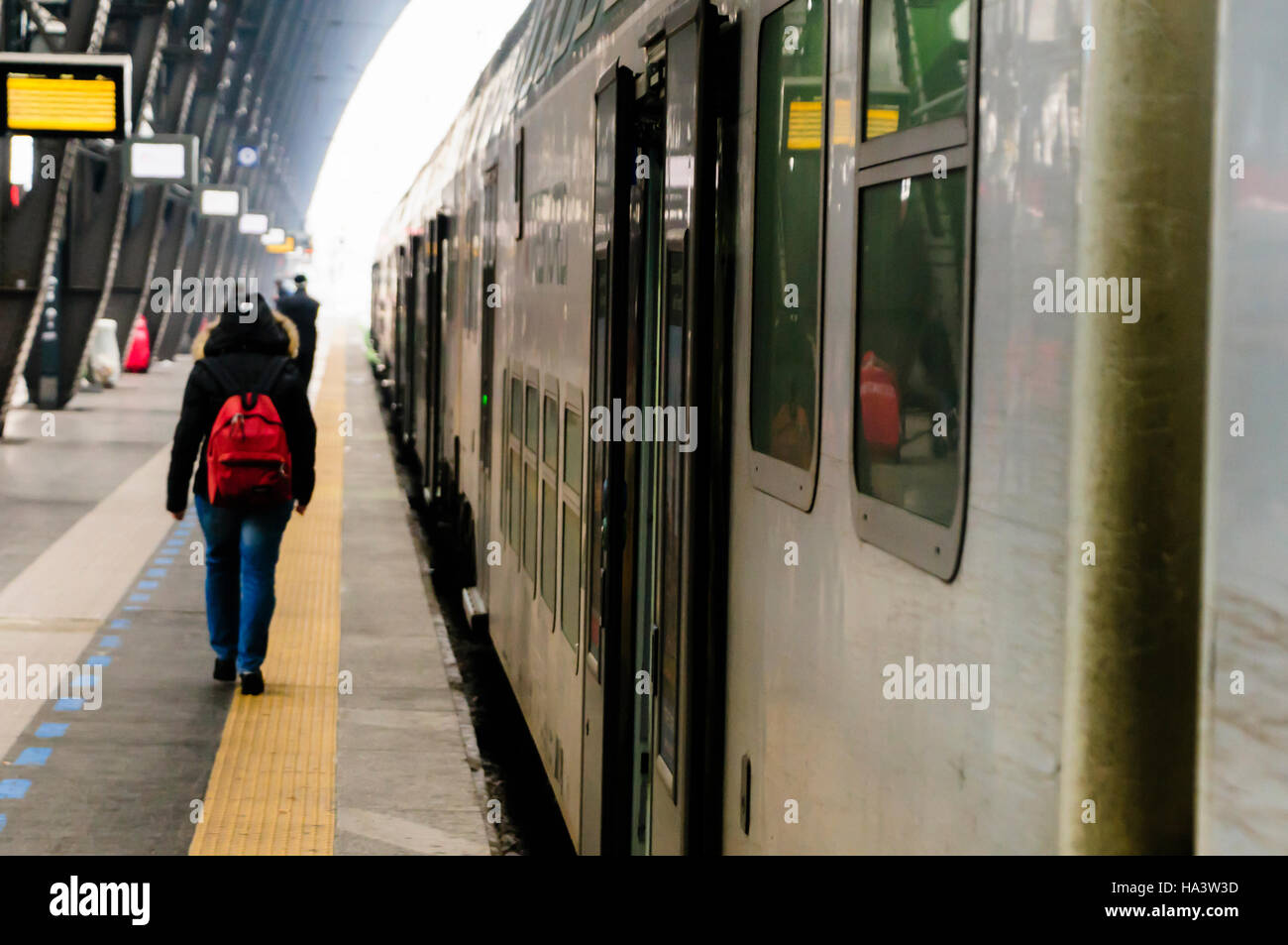 A passenger walks along the platform at Milan Railway Station, about to board a Trenitalia train. Stock Photo