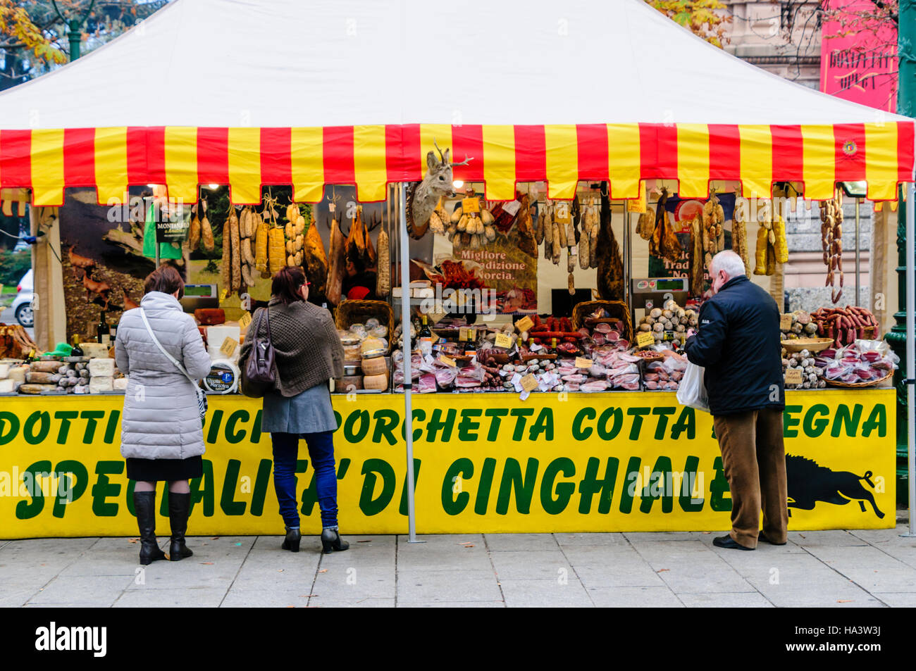 Cheeses, hams and salamis for sale at an Italian market stall in Bergamo, Italy Stock Photo