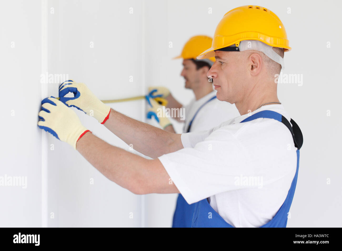 Building teamwork concept - group of smiling builders in hardhats with tools indoors Stock Photo