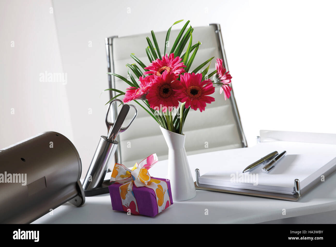 Desk, small flower bouquet and a parcel Stock Photo