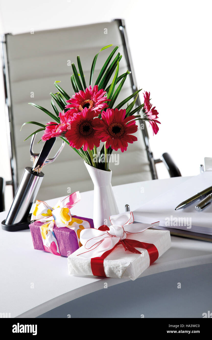 Desk, small flower bouquet and parcels Stock Photo