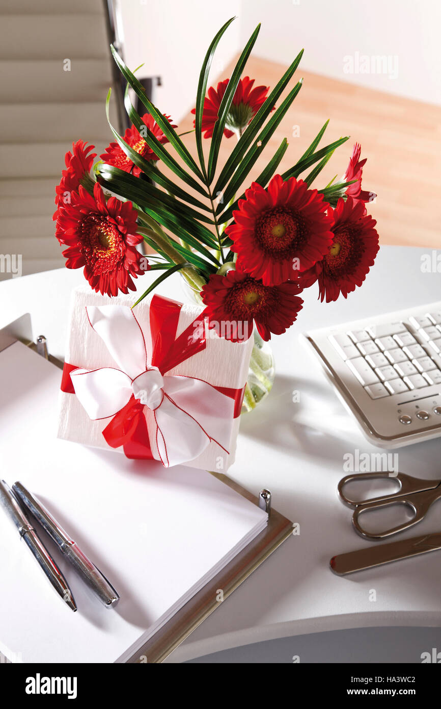 Desk, small flower bouquet and a parcel Stock Photo