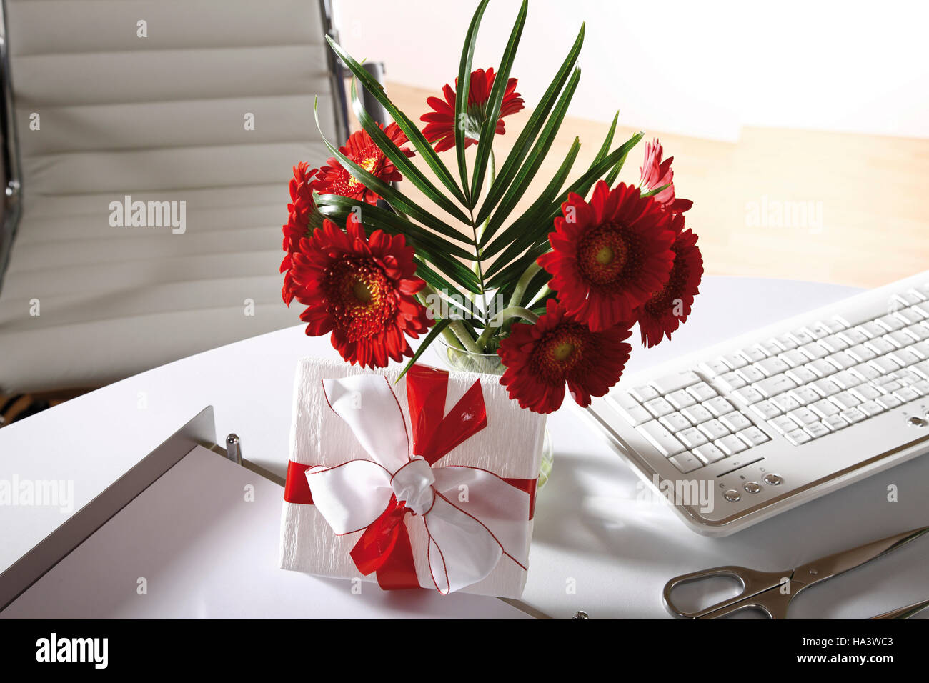 Desk, small flower bouquet and a parcel Stock Photo