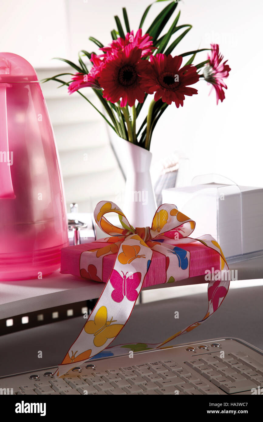 Desk, small flower bouquet and a parcel Stock Photo