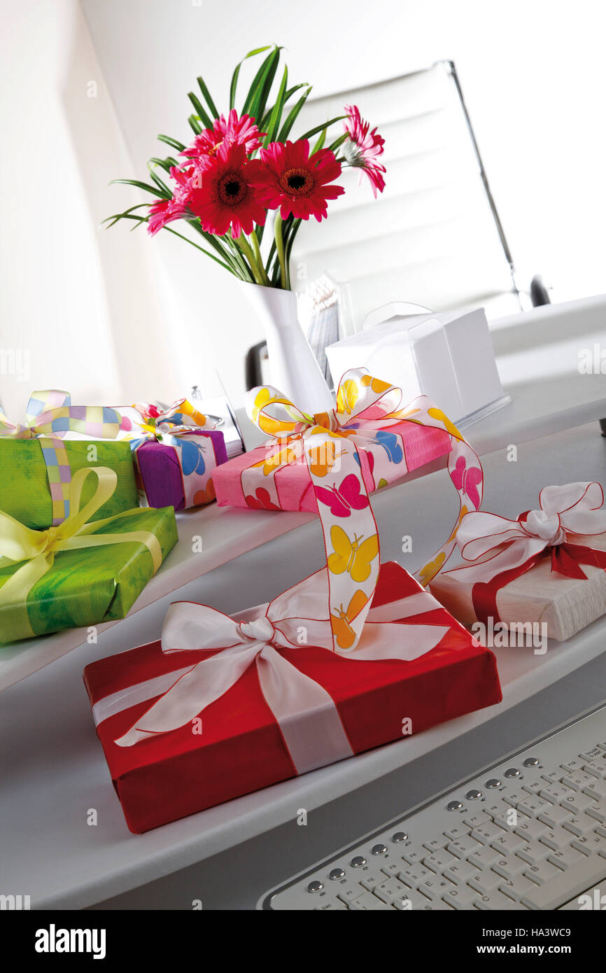Desk, small flower bouquet and parcels Stock Photo