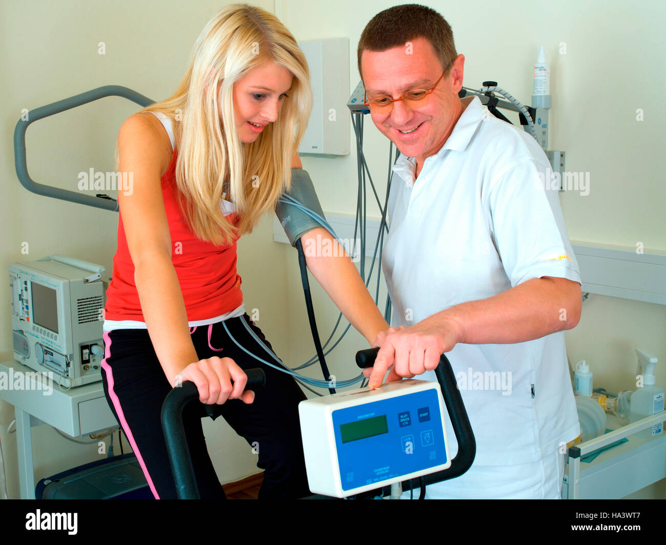 Doctor conducting an ergometer test in a medical practice with a young woman Stock Photo