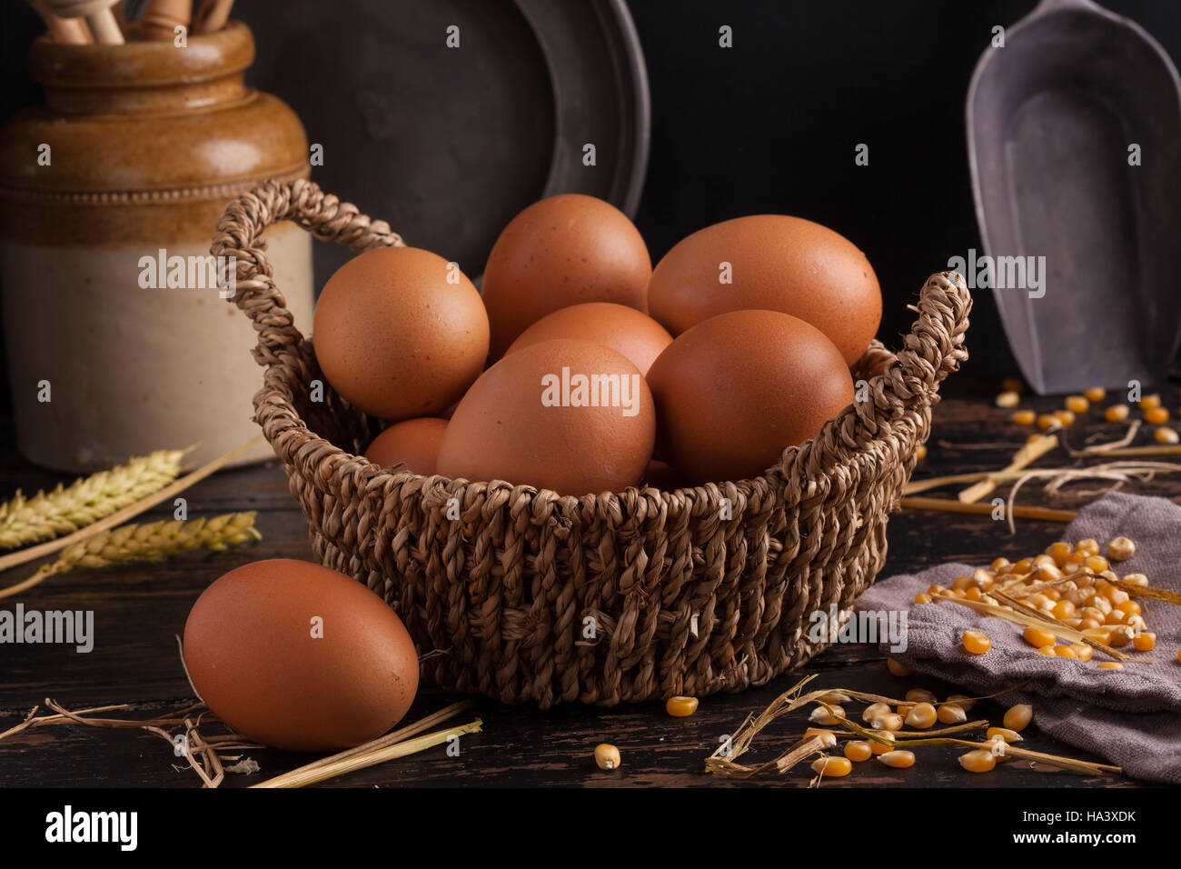 Free range eggs in a basket with corn and straw. Stock Photo