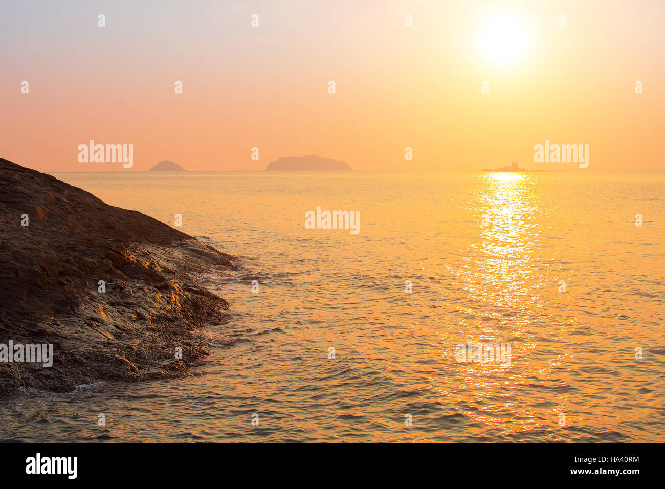 Rocky sea shore against the setting sun. Stock Photo